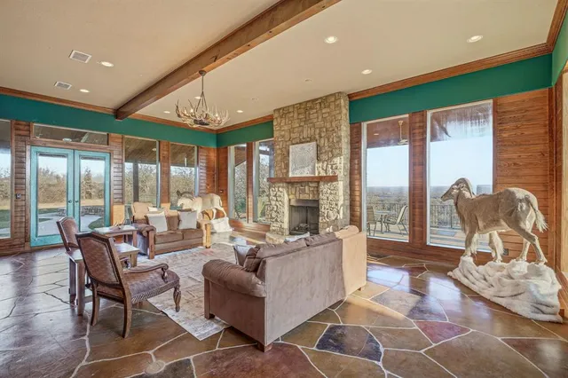 a living room with furniture large windows and wooden floor