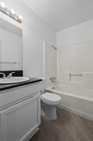 a view of swimming pool with lawn chairs and large tree