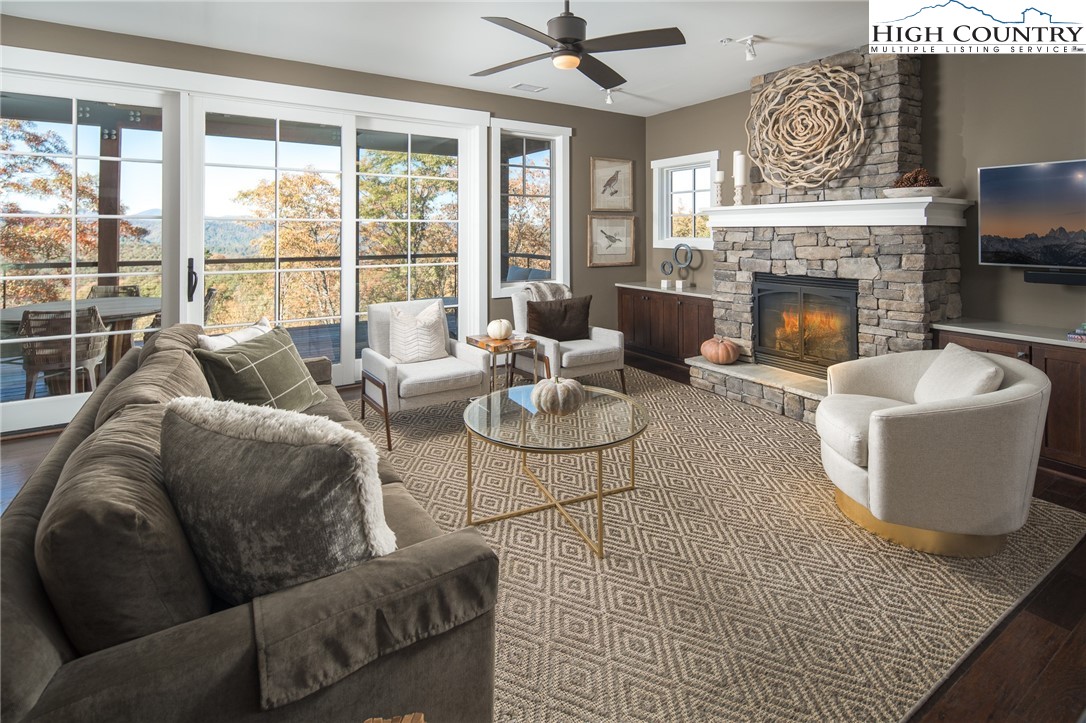 a living room with furniture a fireplace and a large window