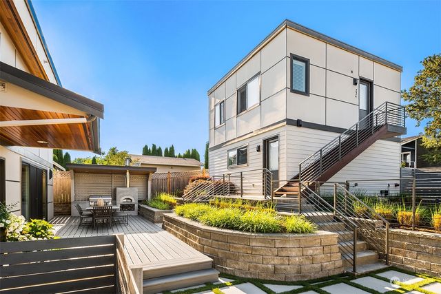 a view of a chairs and table on the wooden roof deck