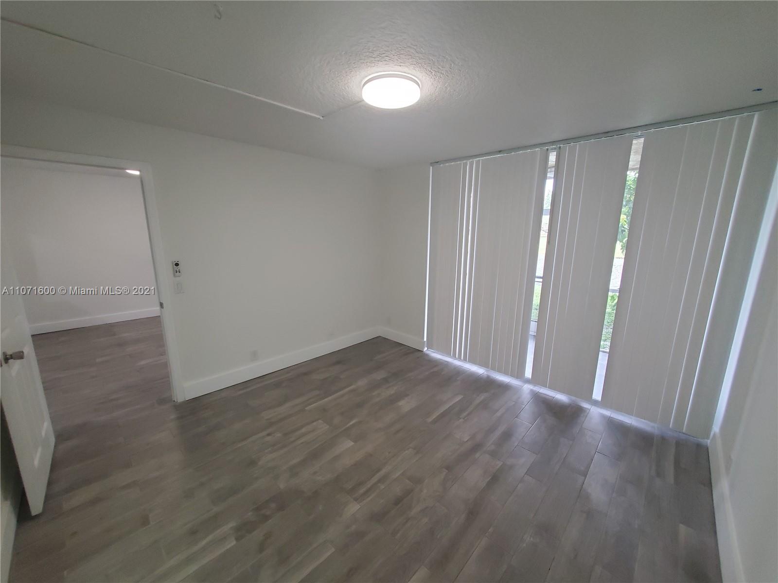 9431 Live Oak Place, Unit 108 Davie, FL 33324 - Photo 14 of 27 a view of an empty room with wooden floor