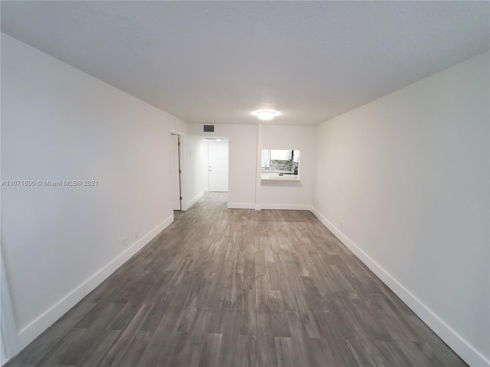 9431 Live Oak Place, Unit 108 Davie, FL 33324 - Photo 15 of 27 an empty room with wooden floor and windows