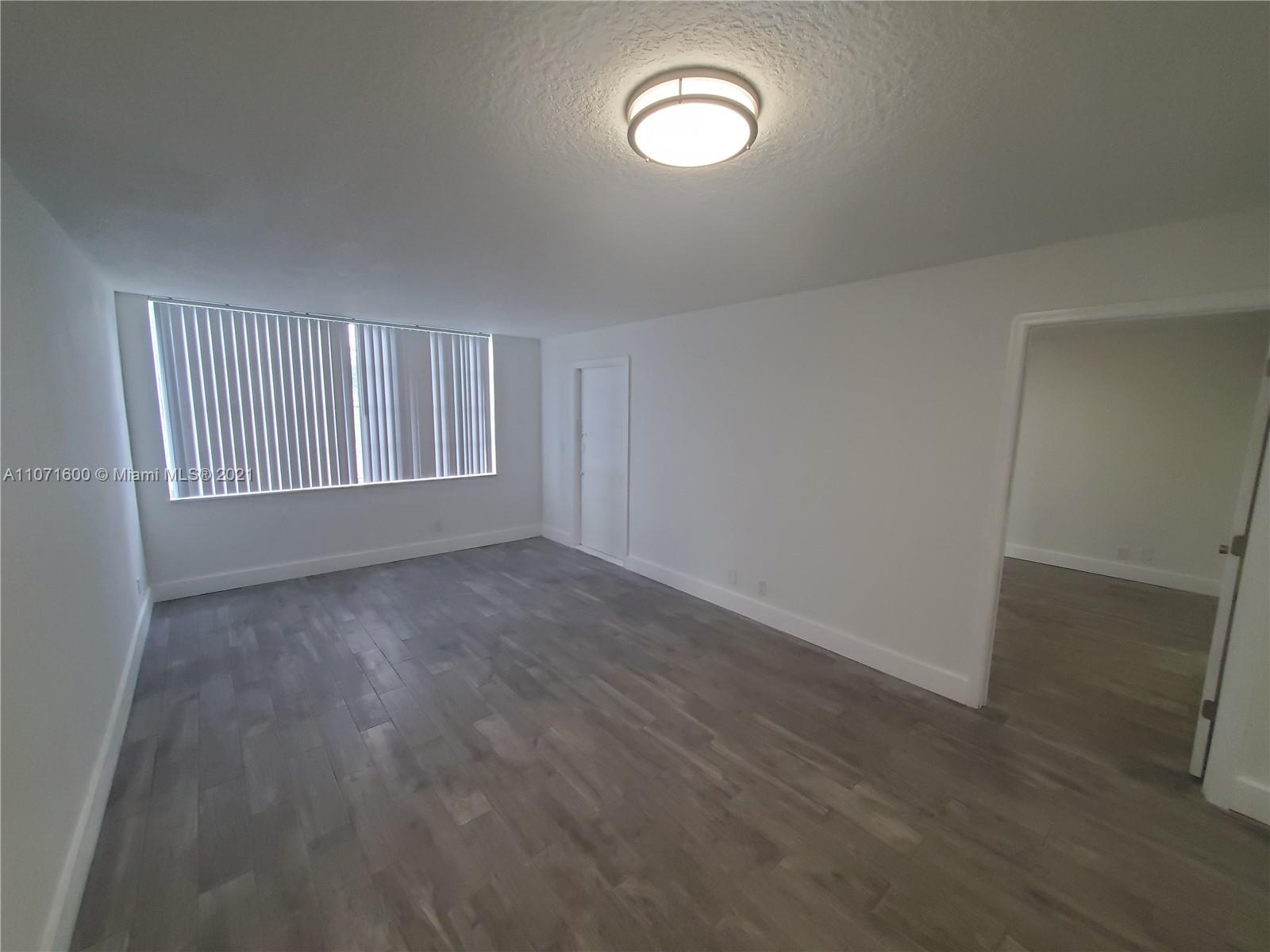 9431 Live Oak Place, Unit 108 Davie, FL 33324 - Photo 17 of 27 an empty room with wooden floor and windows