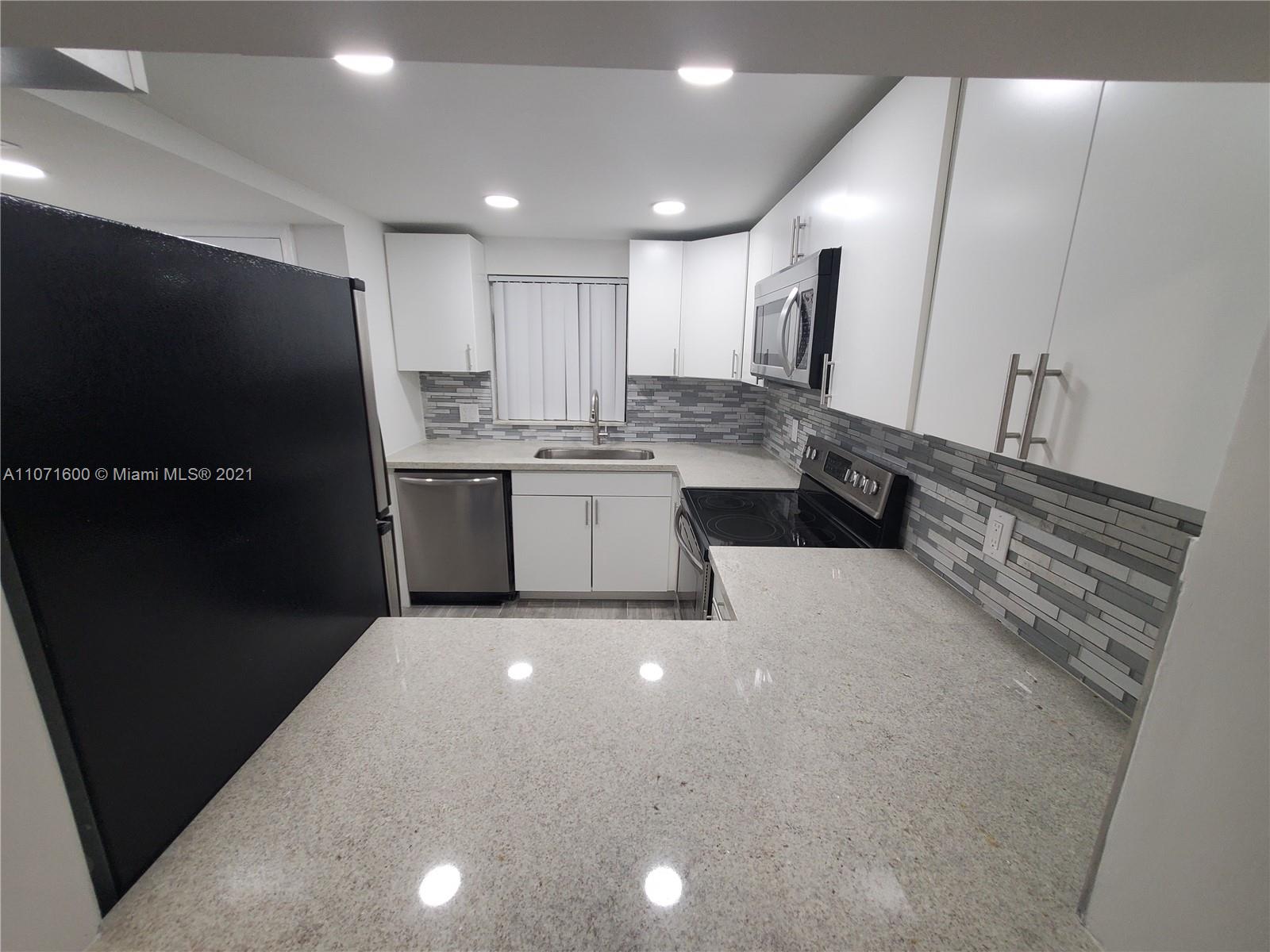 9431 Live Oak Place, Unit 108 Davie, FL 33324 - Photo 19 of 27 a large kitchen with kitchen island a sink stainless steel appliances and cabinets