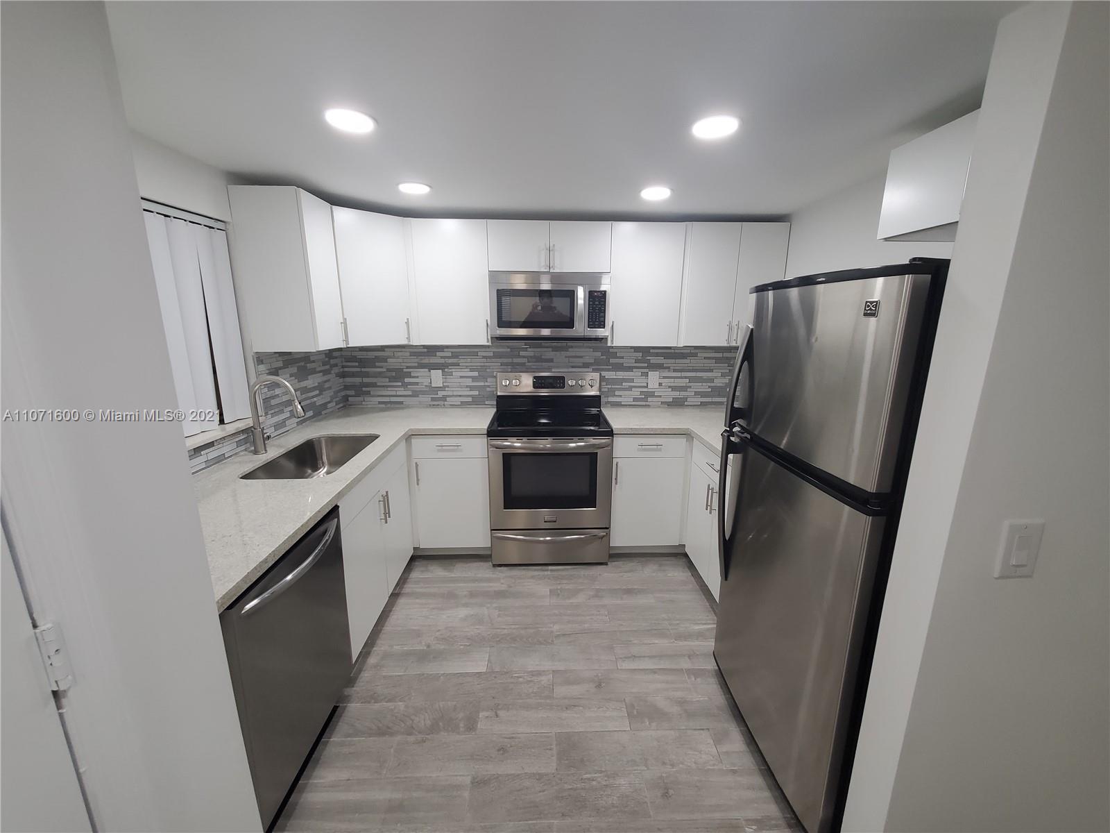 9431 Live Oak Place, Unit 108 Davie, FL 33324 - Photo 2 of 27 a kitchen with stainless steel appliances a refrigerator sink and microwave