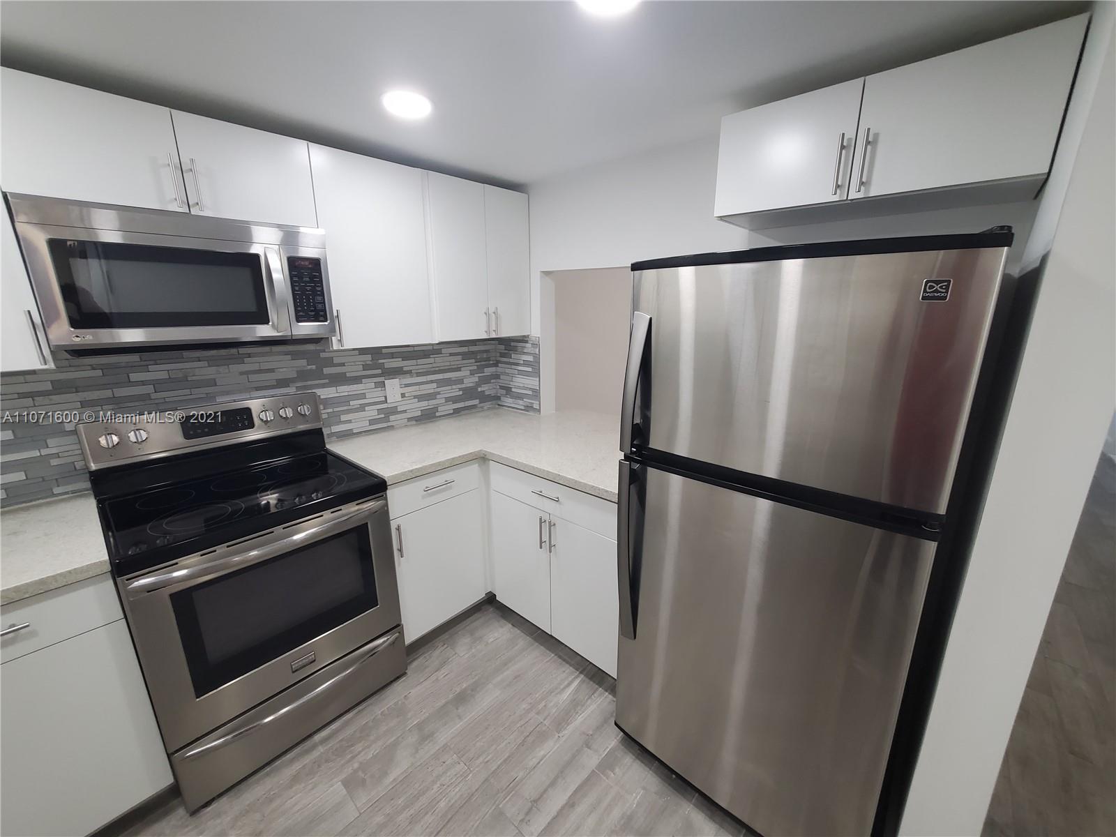 9431 Live Oak Place, Unit 108 Davie, FL 33324 - Photo 3 of 27 a kitchen with a refrigerator stove and microwave