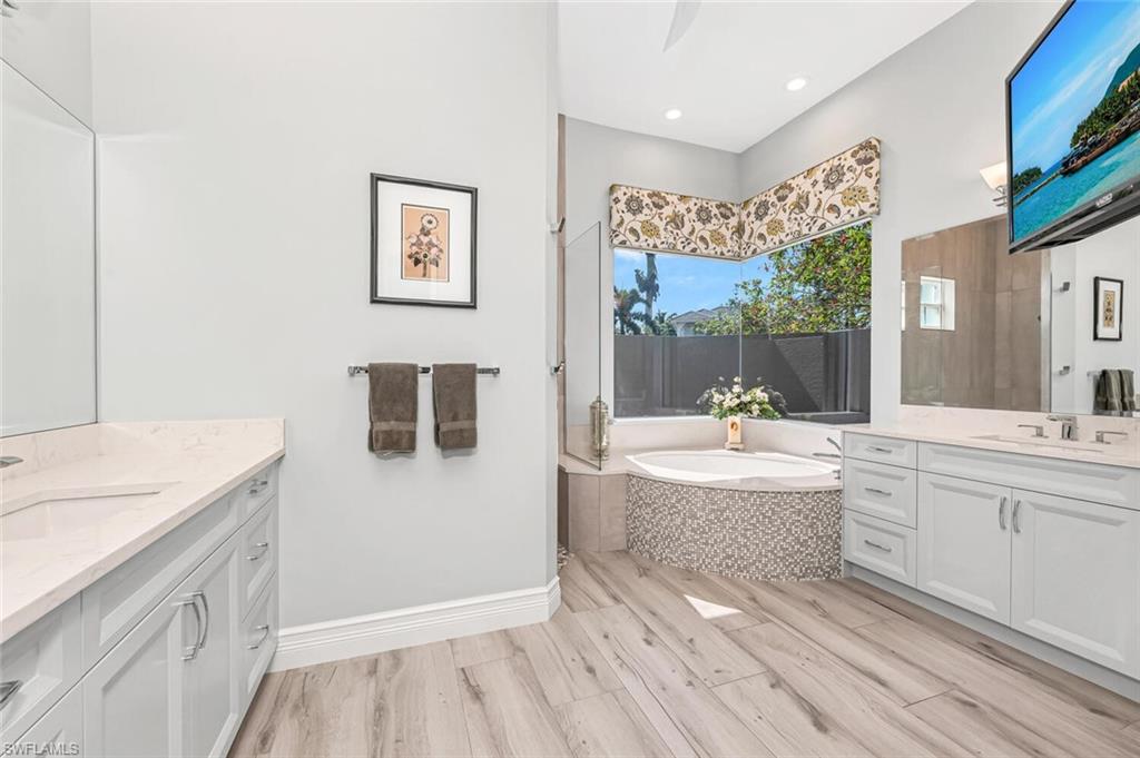 2067 Mission Drive Naples, FL 34109 - Photo 30 of 43 a bathroom with a tub sink and mirror