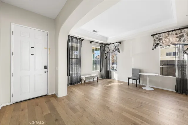 a kitchen with stainless steel appliances granite countertop a stove top oven a refrigerator a dining table and chairs with wooden floor