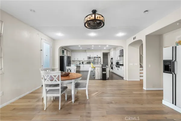 a kitchen with granite countertop white cabinets stainless steel appliances and wooden floor