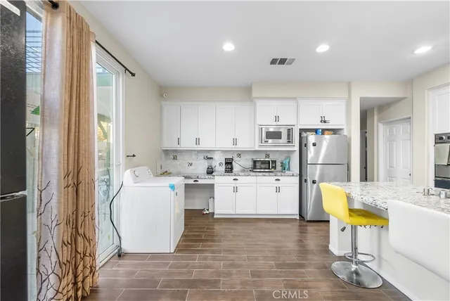 a view of an empty room with wooden floor and closet