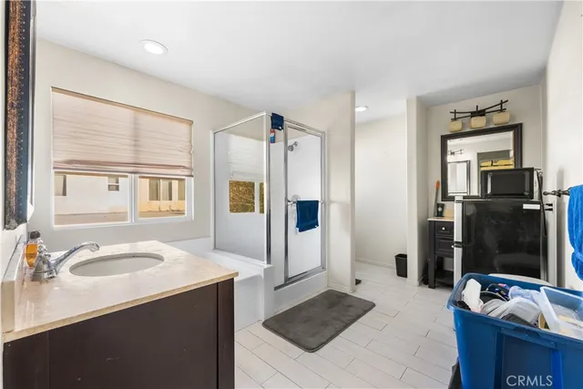 a view of a white house with a small yard and sitting area