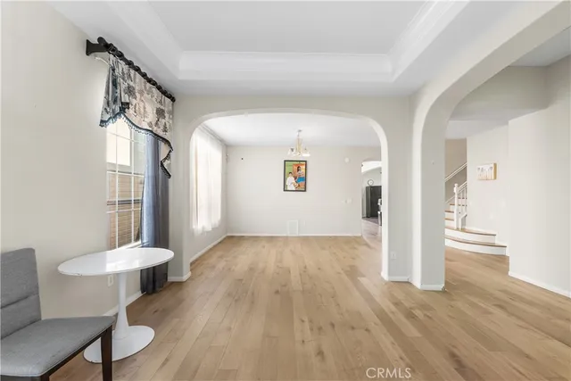 a view of a hallway with wooden floor and a dining room