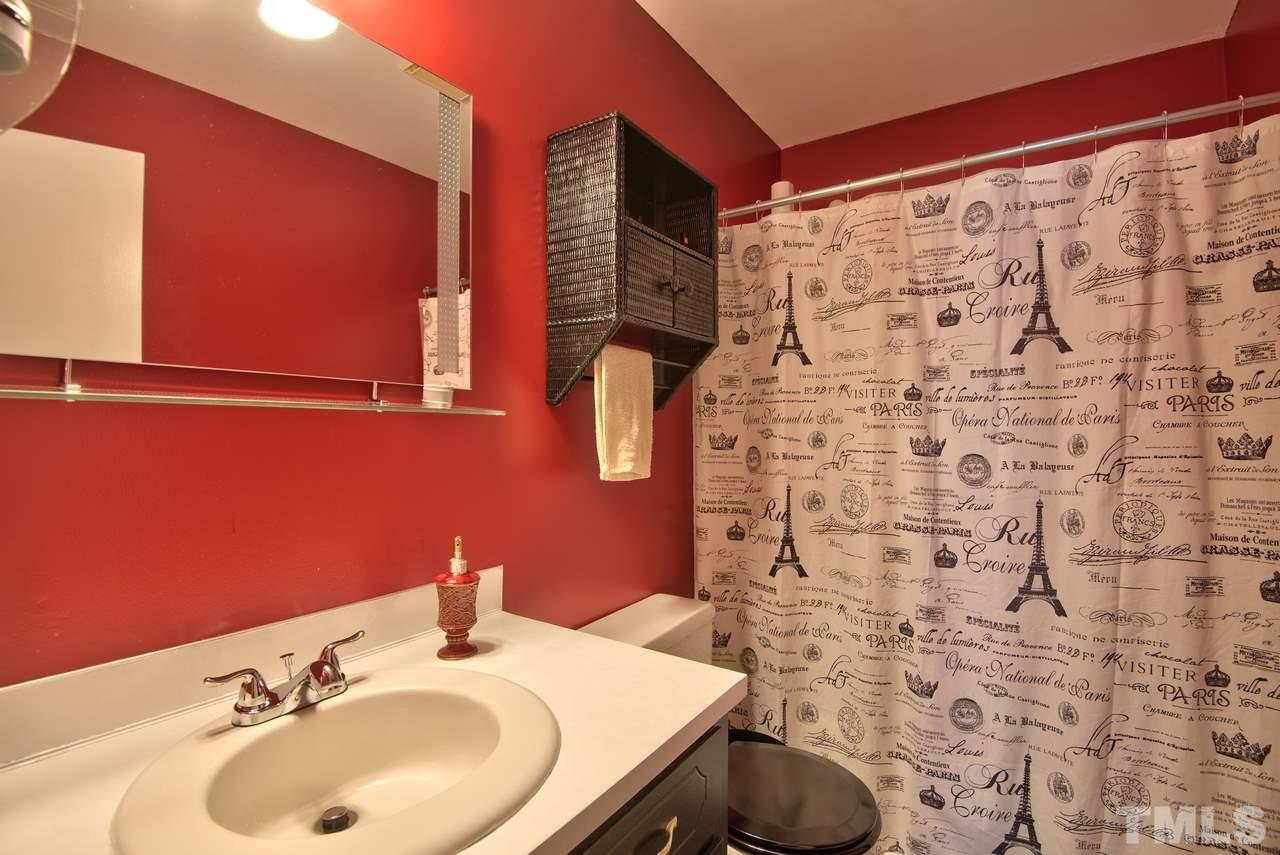 6017 Crabapple Road Durham, NC 27712 - Photo 16 of 18 a bathroom with a sink and a mirror