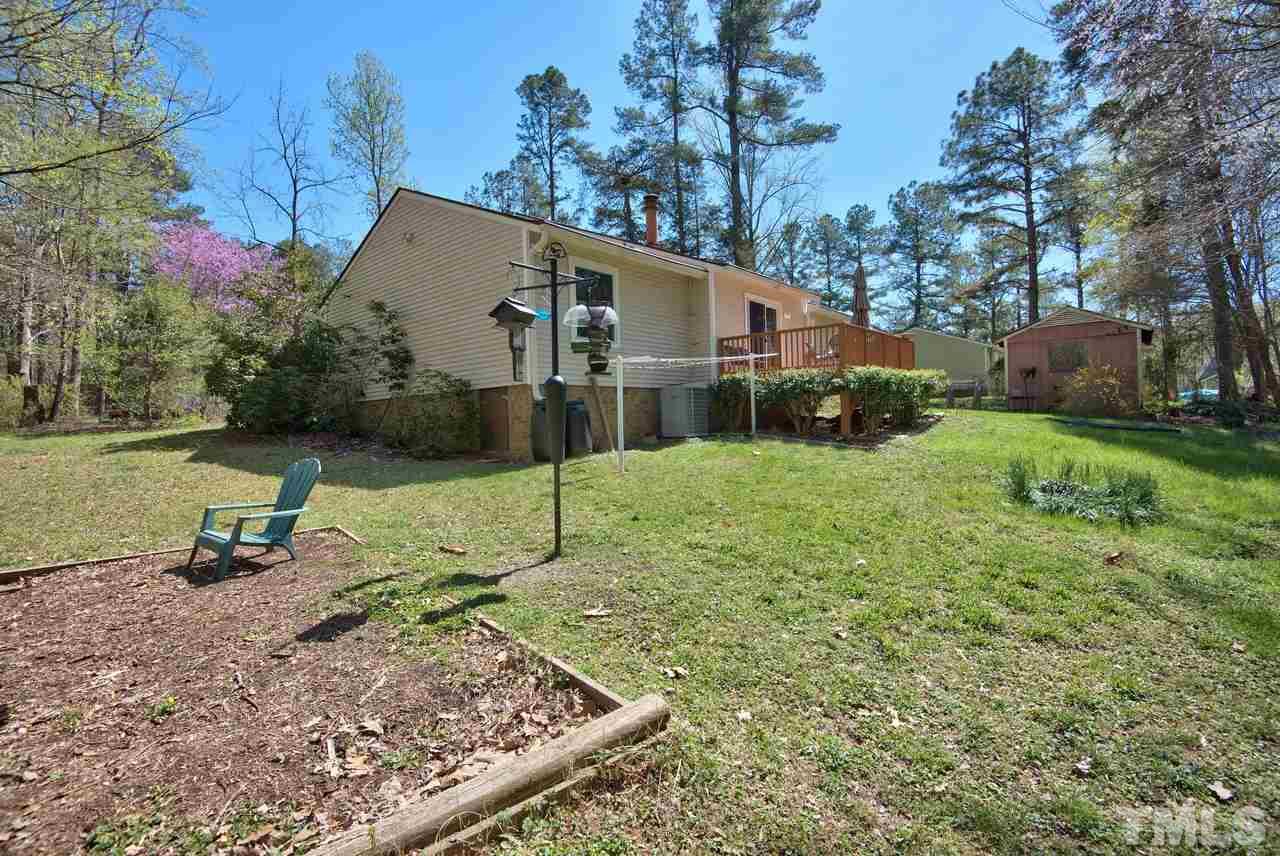 6017 Crabapple Road Durham, NC 27712 - Photo 4 of 18 a backyard of a house with potted plants and large tree
