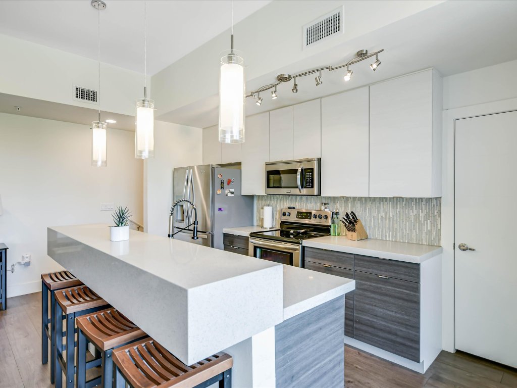 604 North Bluff Drive, Unit 101 Austin, TX 78745 - Photo 11 of 22 a kitchen with stainless steel appliances a sink a stove a refrigerator cabinets and living room view