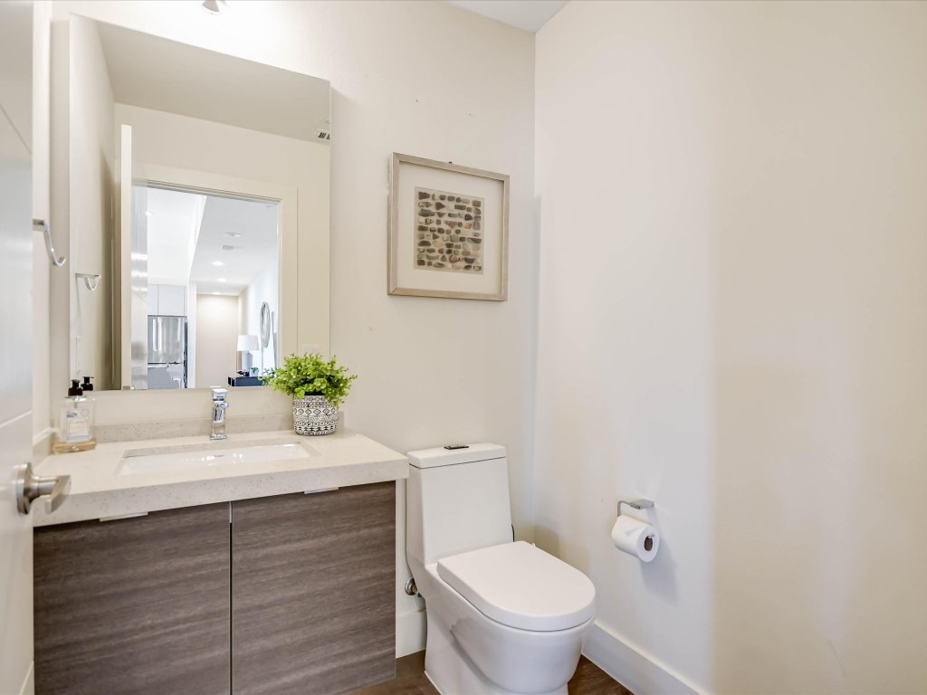 604 North Bluff Drive, Unit 101 Austin, TX 78745 - Photo 17 of 22 a bathroom with a sink vanity mirror and toilet