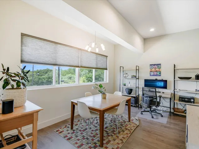 a kitchen with stainless steel appliances a sink a stove a refrigerator cabinets and living room view