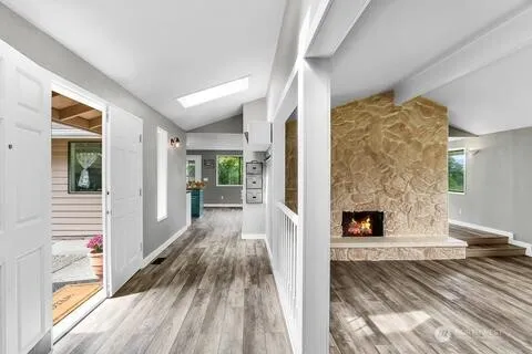 a view of a livingroom with wooden floor and a fireplace