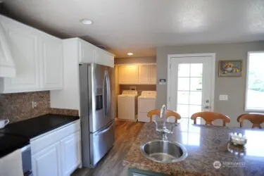 a kitchen with stainless steel appliances granite countertop a sink refrigerator and cabinets