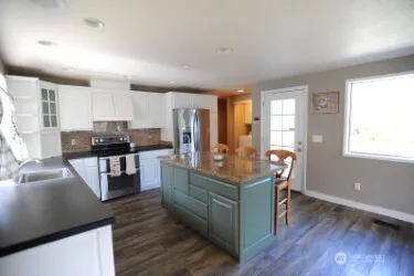 a kitchen with stainless steel appliances granite countertop a stove a sink and a refrigerator