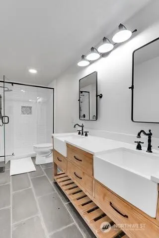 a bathroom with a double vanity sink a toilet and a mirror