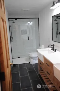 a bathroom with a double vanity sink toilet and shower