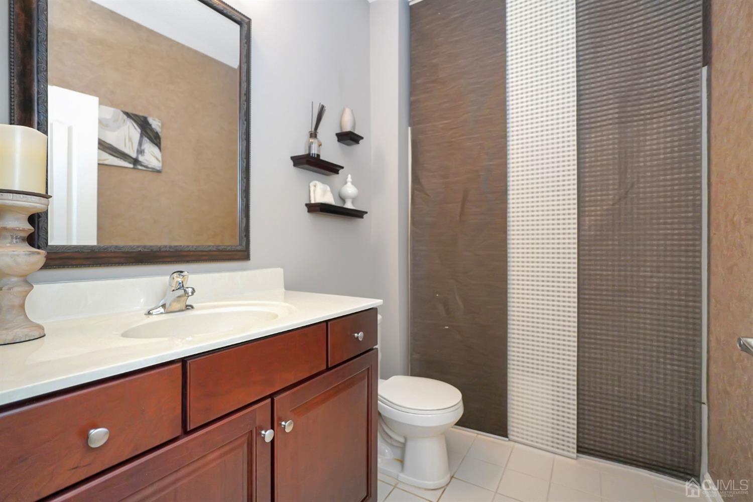 35 Diamond Spring Drive Monroe Township, NJ 08831 - Photo 22 of 32 a bathroom with a sink a toilet and mirror
