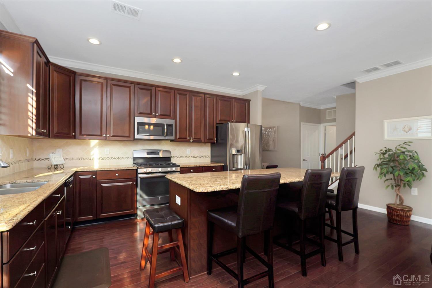 35 Diamond Spring Drive Monroe Township, NJ 08831 - Photo 6 of 32 a kitchen with a table chairs refrigerator and microwave