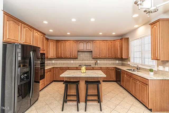 a kitchen with stainless steel appliances granite countertop sink refrigerator and microwave