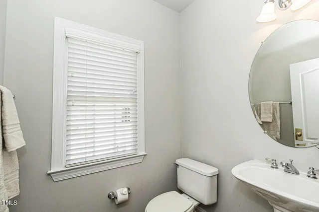 a bathroom with a toilet a sink and a mirror