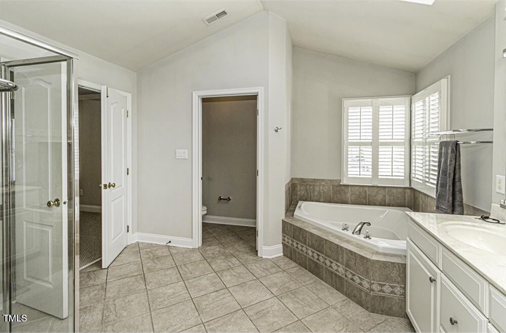 9244 Palm Bay Circle Raleigh, NC 27617 - Photo 23 of 29 a bathroom with a bathtub and a shower