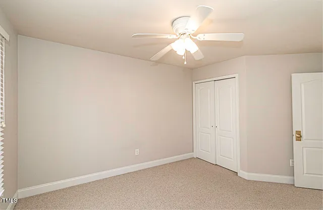an empty room with a fan and a fan