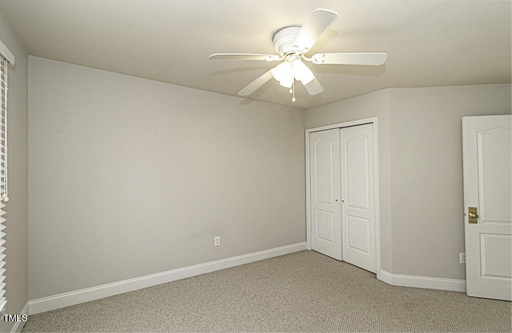 9244 Palm Bay Circle Raleigh, NC 27617 - Photo 26 of 29 an empty room with a fan and a fan