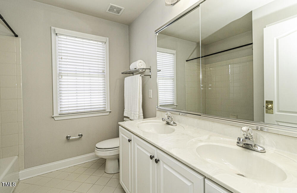 9244 Palm Bay Circle Raleigh, NC 27617 - Photo 27 of 29 a bathroom with a granite countertop sink toilet a large mirror and shower