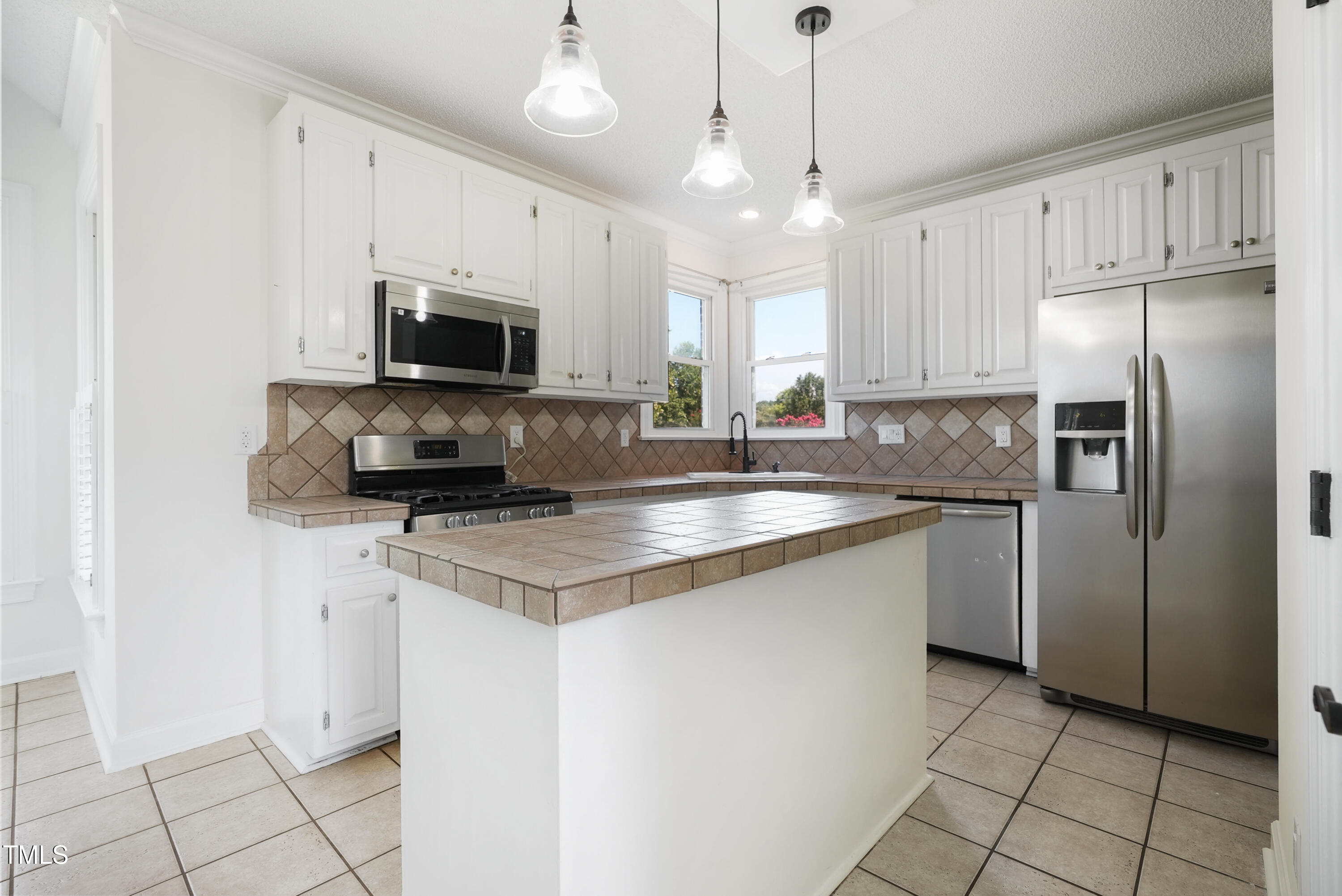 1010 Warren Road Erwin, NC 28339 - Photo 19 of 54 a kitchen with stainless steel appliances a stove a sink a refrigerator a microwave and cabinets