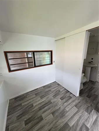 a view of a hallway with wooden floor and cabinet