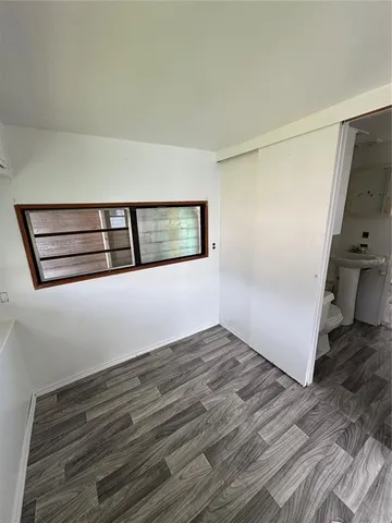 a view of a hallway with wooden floor and cabinet