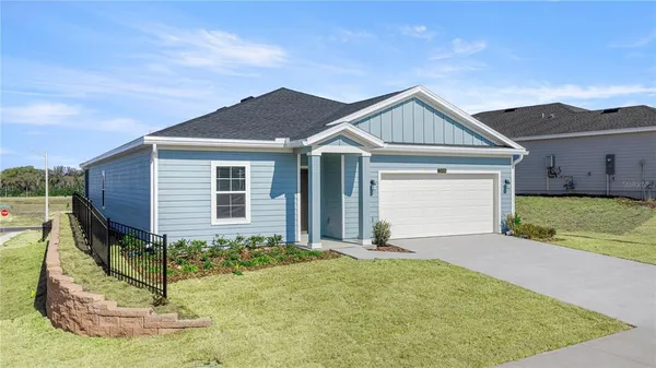 a view of a house with a small yard and potted plants