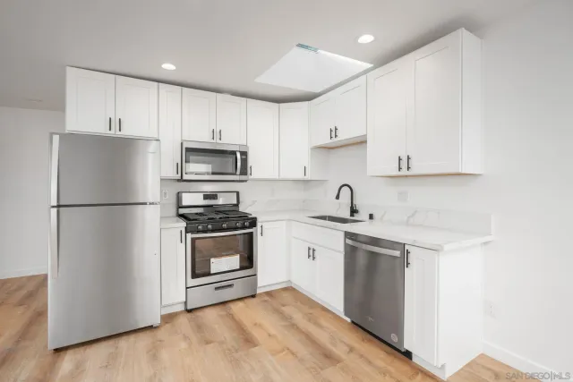 a view of kitchen with refrigerator and microwave