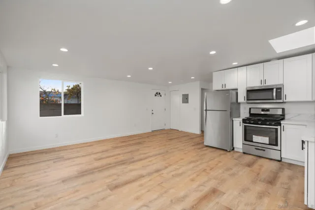 a bathroom with a granite countertop sink a toilet a mirror and bathtub