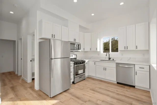 a kitchen with white cabinets and a stove with a sink
