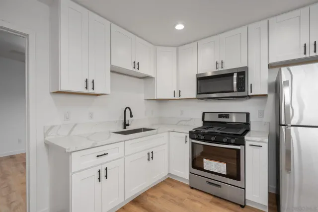 a kitchen with white cabinets and a stove