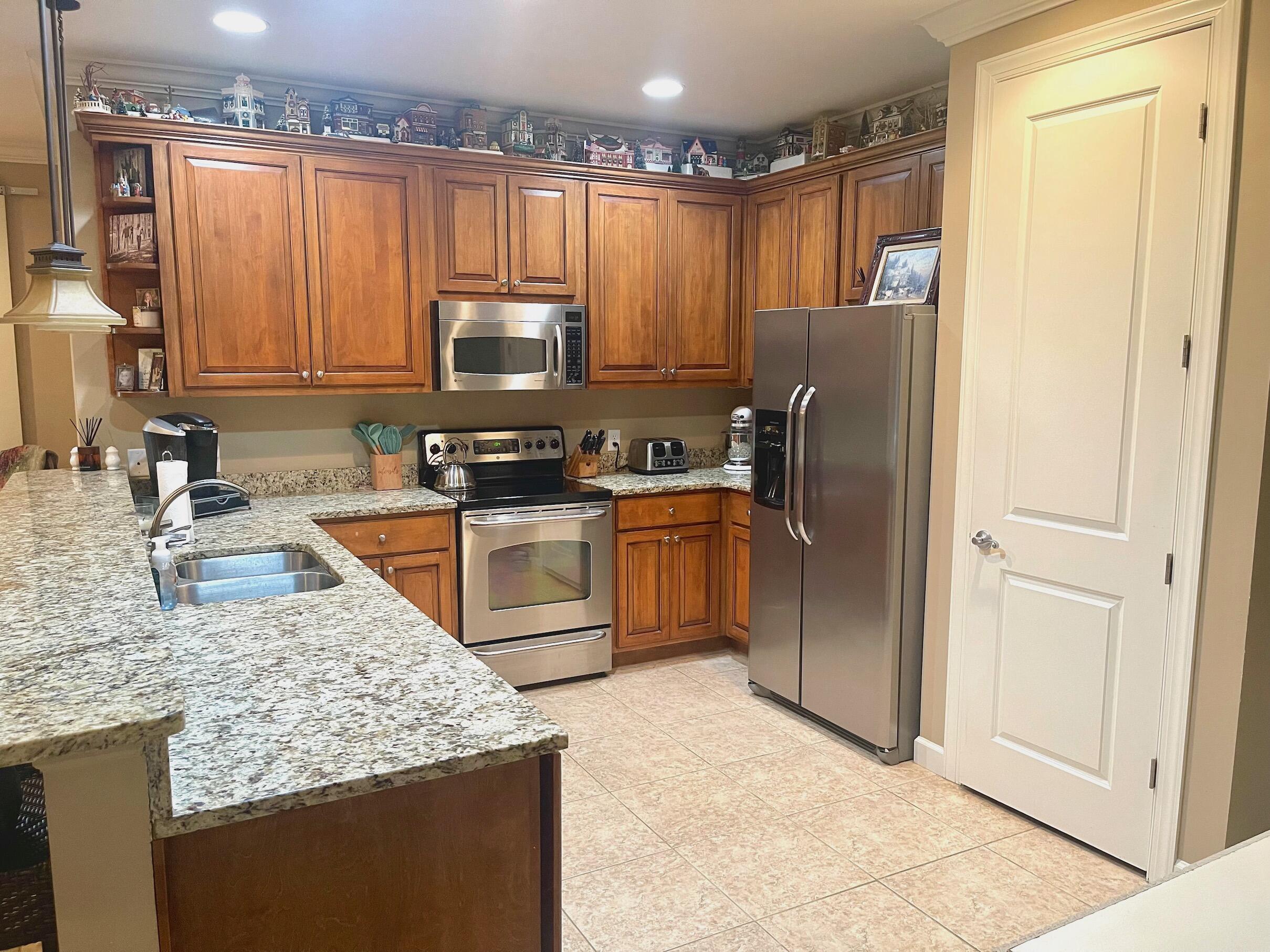 184 South Zander Way Santa Rosa Beach, FL 32459 - Photo 24 of 36 a kitchen with kitchen island granite countertop a sink stove refrigerator and cabinets