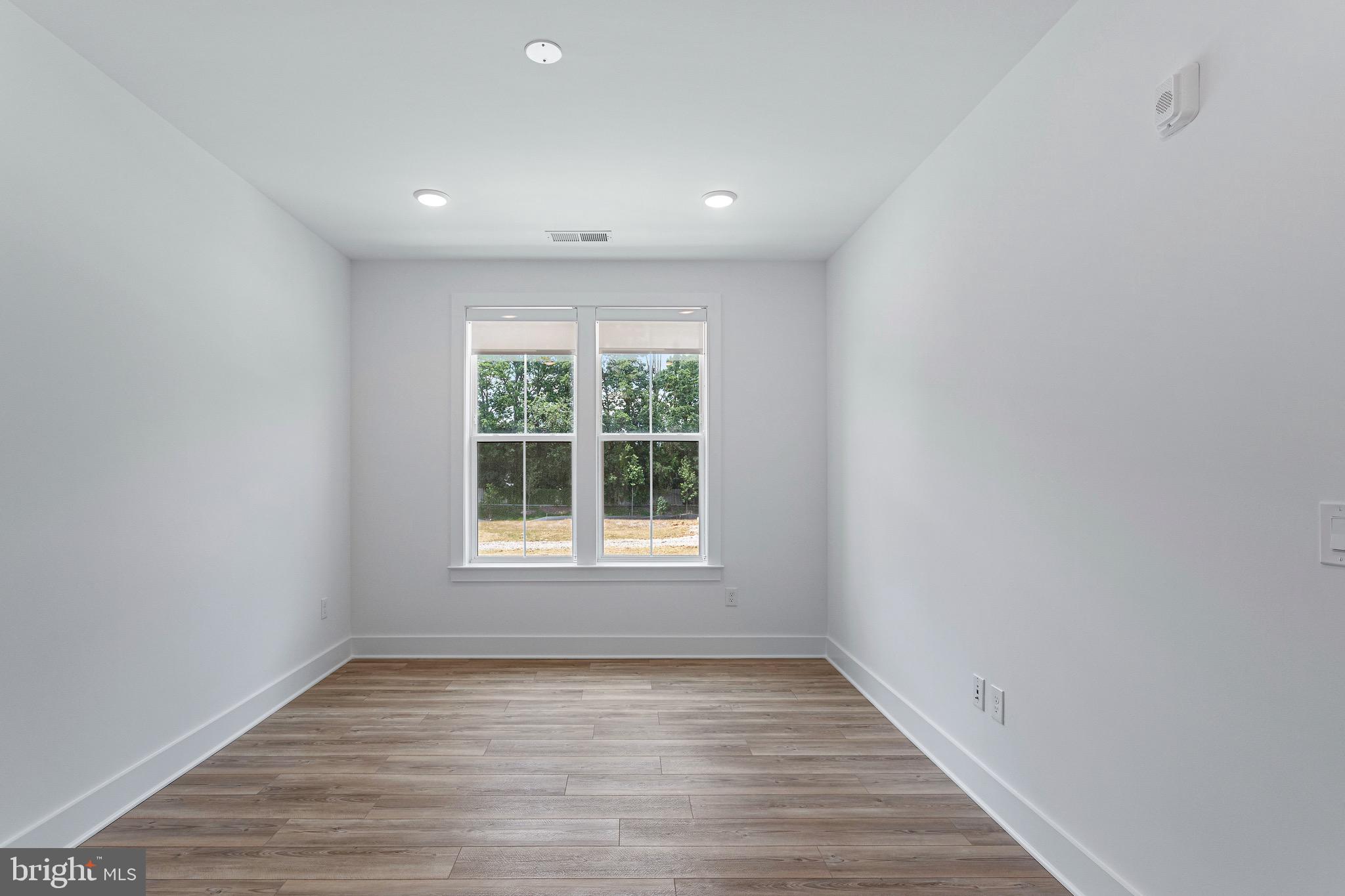 78 Old Mill Bottom Road North, Unit 107 Annapolis, MD 21409 - Photo 27 of 39 an empty room with wooden floor and windows