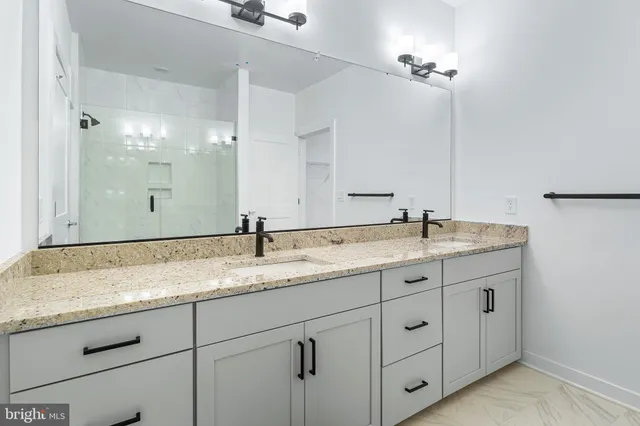 a bathroom with a granite countertop sink double and mirror