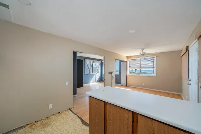 a living room with stainless steel appliances wooden floor and a window