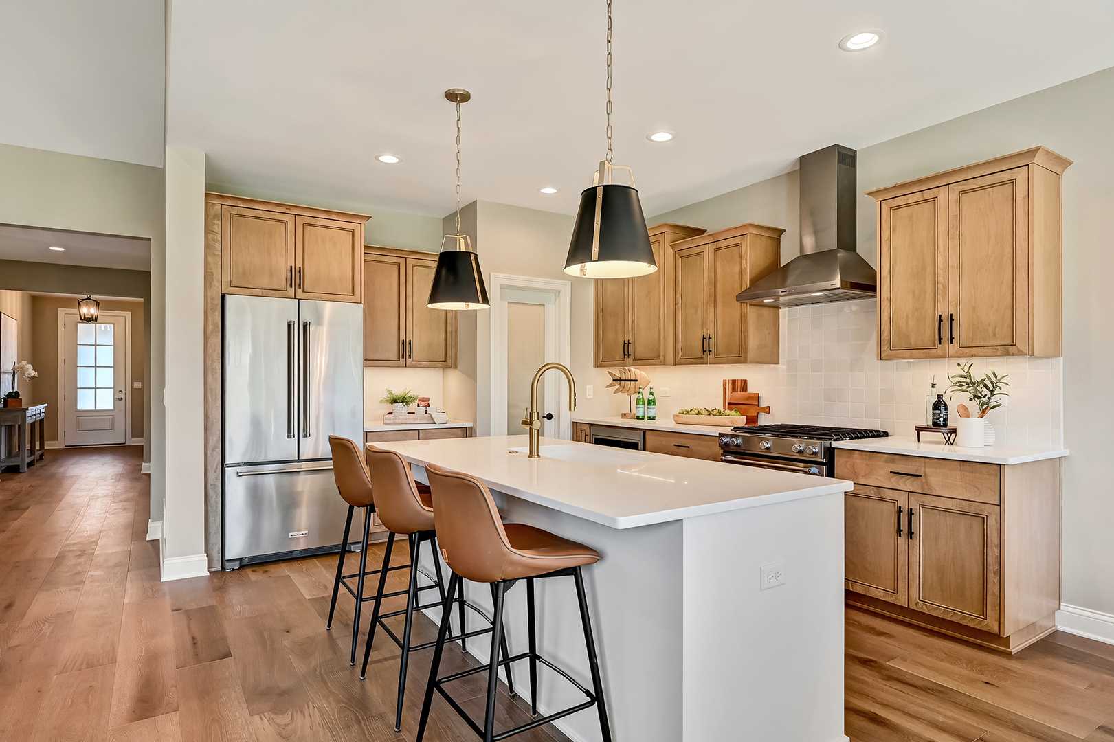 12235 Copper Ridge Drive, Unit 18 Lemont, IL 60439 - Photo 7 of 30 a kitchen with stainless steel appliances a refrigerator a stove a sink dishwasher and white cabinets with wooden floor