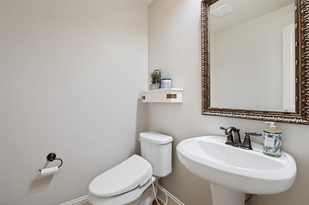 4646 G Rhett Lane Carrollton, TX 75010 - Photo 5 of 16 Pedestal sink with bronze-finish faucet, framed mirror, and wall-mounted toilet