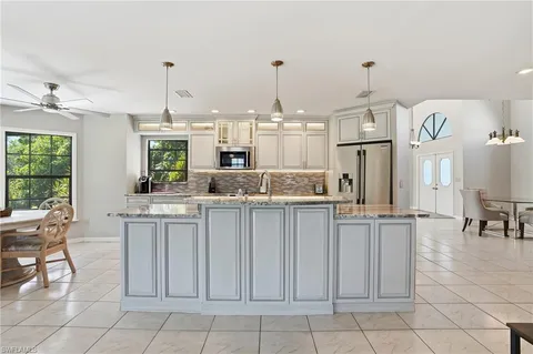 a kitchen with white cabinets and sink