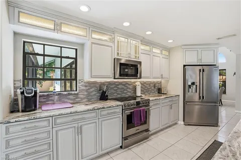 a kitchen with granite countertop a sink stainless steel appliances and cabinets